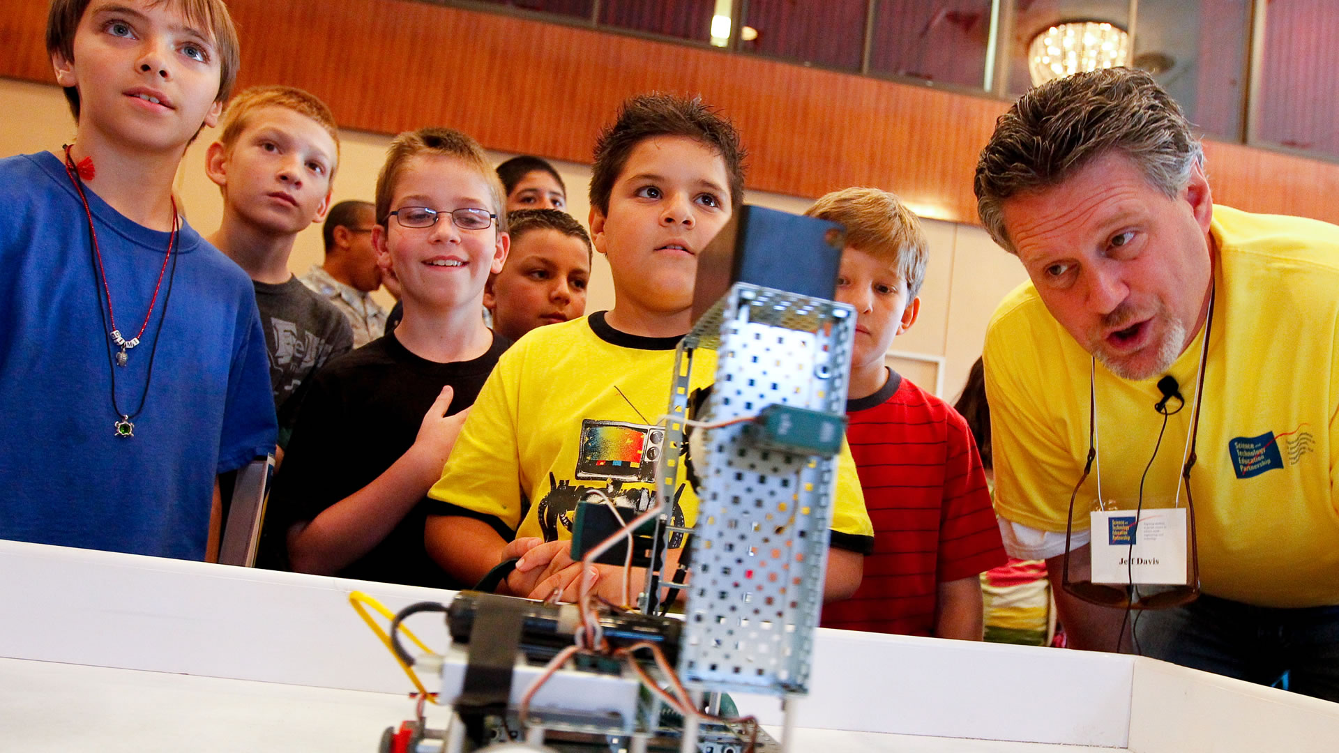 Teacher and students operating a small robot.